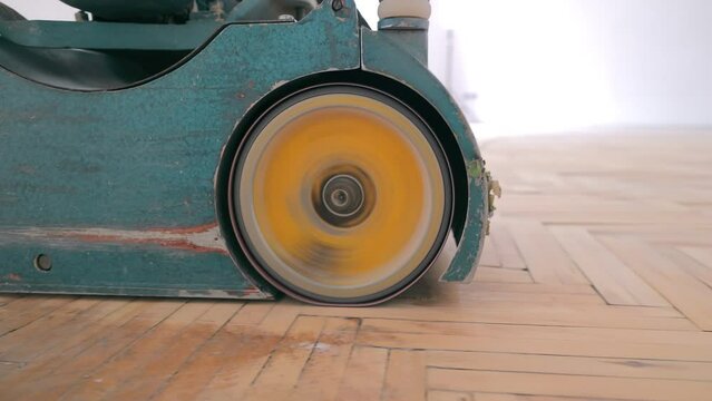 Close-up of parquet sanding with a special sanding machine. Repair and restoration of parquet floors