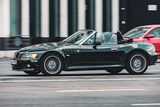 BMW Z3 car rides on street on high speed. Black roadster with inline-six engine in fast motion, side view