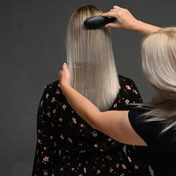 Hairdresser's Hands Combing Model's Hair From Behind