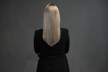 Back rear spine view photo of blond haired young woman pretty lovely natural hair isolated on gray background