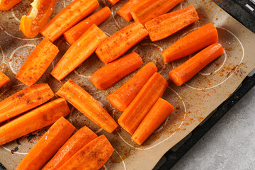 Fresh carrots, orange bell pepper and tomatoes cut in long strips placed on on the oven rack ready...