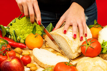 Horizontal shot of female hands cutting some bread