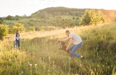 young man playing with his dog outdoors. French bulldog and guy having fun in countryside