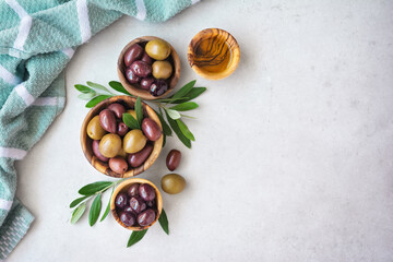 Wooden bowls with delicious olives and oil
