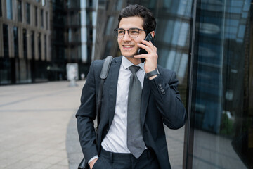 A male manager talks on a telephone in a business suit goes to work in the office with a briefcase