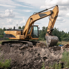 Crawler excavator digs the earth with a bucket. Drainage of swamps. Clearing the construction site. Excavators are used when working in quarries and mine workings.