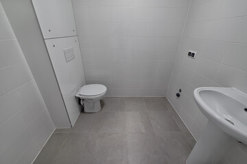 Small new bathroom with toilet, sink. Standard, stereotype bathroom in a new apartment