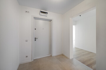 Empty room after repairs in an apartment building. Standard, stereotype fresh renovated room with wooden floor