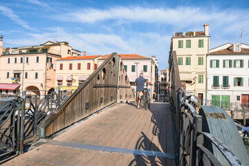 Fototapeta na wymiar Wooden footbridge across water canal in Chioggia