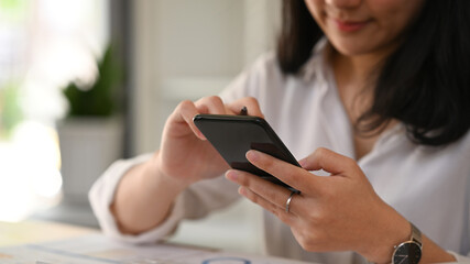 Cropped view of view woman hand typing text message, chatting online on smart phone