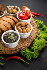 Dish with assorted marinated vegetables on wooden background