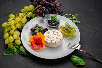 Dish with cheese camambert with fruits on wooden background