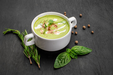 Green spinach cream soup on wooden background