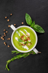 Green spinach cream soup on wooden background