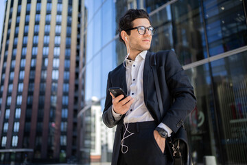 A man holding a phone is a manager, an employee in a financial company, goes to the office in a business suit, builds a career