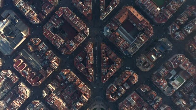 Streets and buildings lit by low sun. Overhead view of development in Eixample district. Barcelona, Spain