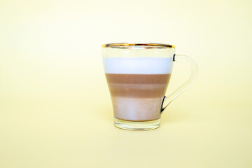 cup of coffee with milk foam on yellow background