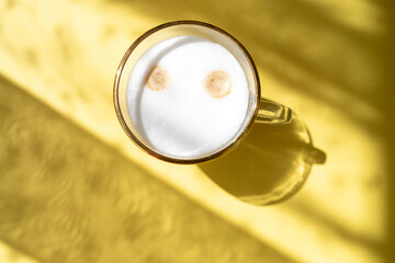 cup of coffee in morning light, sunlight shadow, morning breakfast concept, top view on yellow background