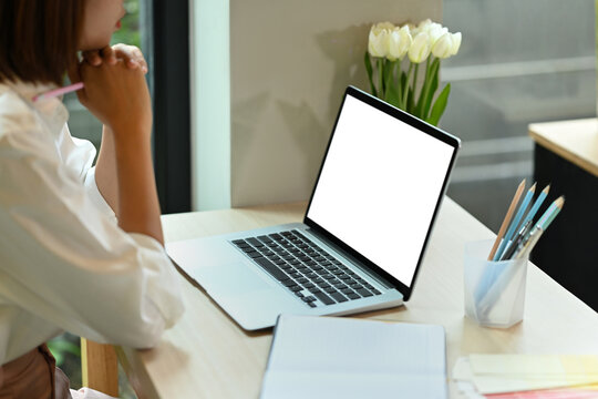 Cropped images of young woman entrepreneur sitting front of laptop and thinking about her business plan