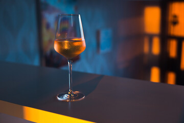 A glass of wine, water, lights up, glares against the background of the setting sun. Sunset in a glass.
