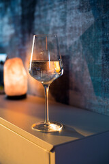 A glass of wine, water, lights up, glares against the background of the setting sun. Sunset in a glass.