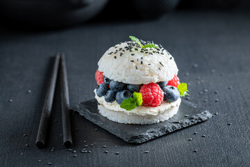 Tasty sushi burger with berries and mascarpone sprinkled with seeds.