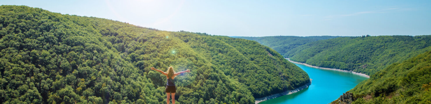woman on a peak looking at mazing landscape view with forest and river ( Dordogne,  roc du busatier, gratte bruyere)