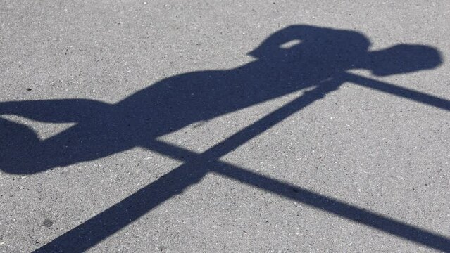Shadow of bodybuilder performing a push-up exercise on the uneven bars with an emphasis on triceps. Shadow of muscular athlete shows the full power of human body and motivates you to play sports