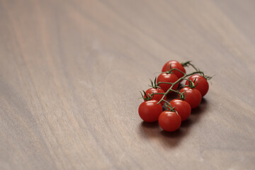 bracnh of fresh cherry tomatoes of wood table