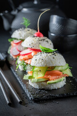 Unique sushi burger with vegetables and seafood as Japanese appetizers.