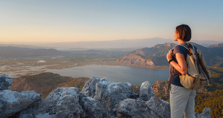 Travel to Turkey, viewpoint over Dalyan Iztuzu Beach. . Smiling woman taking break on hiking trip...