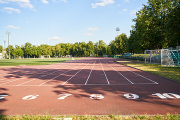 Running track. Red treadmill at the stadium with white lines.