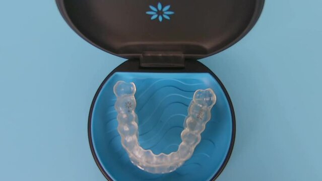 Invisalign braces or invisible transparent aligner on blue background top view