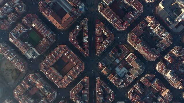 Top down footage of symmetrical town development. Fly above blocks of buildings in urban borough. Barcelona, Spain