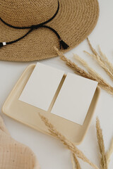 Paper sheet cards with mockup copy space. Straw hat, muslin blanket, pampas grass stems, neutral...