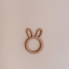 Toy teether for baby to chew. Teething toy on pink background. Neutral pastel colours. Flat lay, top view