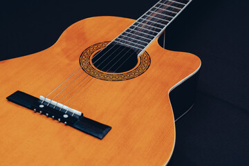Six-string acoustic guitar on a dark brown background. Classical Spanish guitar. Musical...
