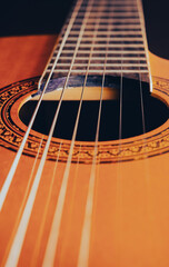 Obraz premium Rosette and strings of an acoustic guitar close up. Classical Spanish guitar. Musical instrument.