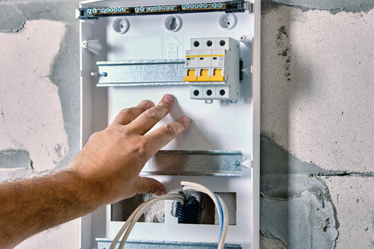 Fastening circuit breakers on DIN rail mounting when installing electrical panel consumer unit of distribution board or switchboard.