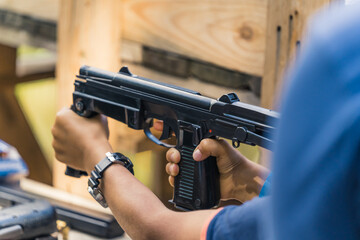 Child holding polish PM Rak submachine gun. Target practice. Firearm training at outdoor shooting...