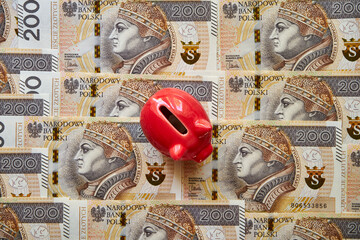 polskie banknoty 200 złotowe i skarbonka 