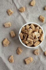 Raw Organic Demerara Granulated Brown Sugar in a Bowl, top view. Flat lay, overhead, from above.