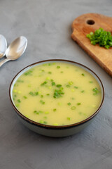 Homemade Potato Leek Soup in a Bowl on a gray surface, low angle view.
