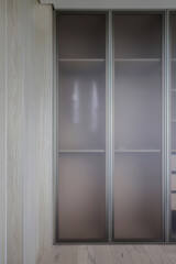 Fototapeta na wymiar Built-in wooden wardrobe with frosted glass