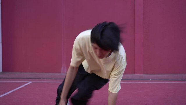 Contemporary Asian dancer outdoors dancing hip hop. Young man dancing hip hop in the street