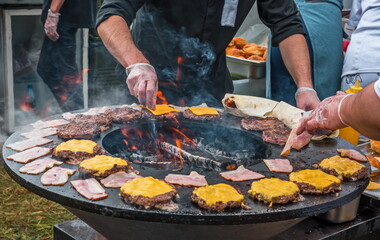 cooking meat with cheese for burgers outdoors