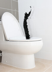 A stream of black liquid springs from a toilet bowl