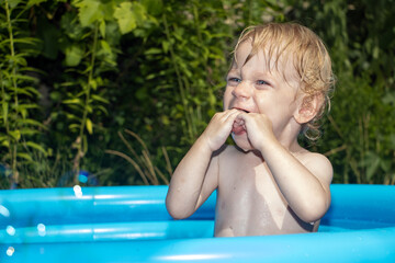 Portrait of a little boy in an inflatable pool