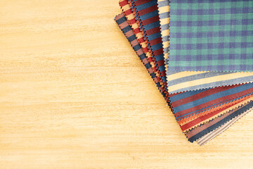 Fabric textile catalog on wooden table. Fabric samples upholstery and decoration.