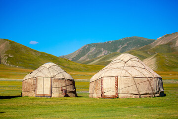 Yurt. National old house of the peoples of Kyrgyzstan and Asian countries. national housing. Yurts on the background of green meadows and highlands. Yurt camp for tourists.